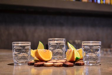 Kafatası bardaklarında tekila, portakal ve limon dilimleri.