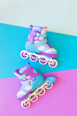 Mavi ve mor arka planda mor patenler. Pastel yaratıcı konsept. Minimalizm, düz uzanma,