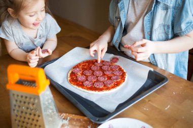 Çocuklar evde pizza hazırlar. Çocuklarla eğlenceli aktiviteler. Çocuk mutfağında yemek pişirir..