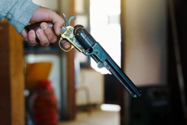 Kafkas asıllı bir adamın elinde eski siyah barut perküsyon ordu tabancası, klasik silah kopyası. İç Savaş, eski vahşi batı tarzı gündüz görüşünde.