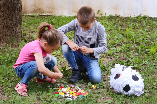 Two Kids Eat Sweets Candy Ground Garden Broken Pinata Toy — Stock Photo, Image