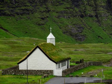Faroe Adaları. Saksun. Yeşil çim çatılı eski beyaz kilise.