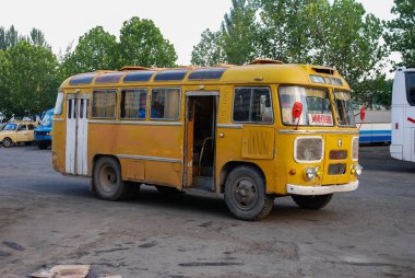 Kırgızistan, Bishkek caddesindeki eski sarı otobüs. Otobüsün kalesindeki plaka Rusça 'da nereye gidileceğini gösteriyor, tercümesi:.