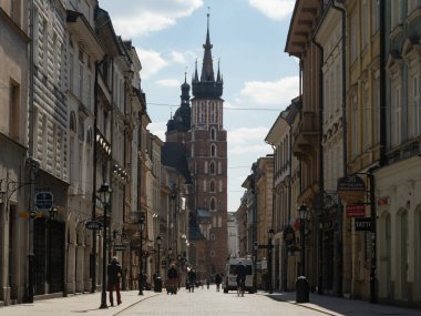 Krakow / Polonya - 22 / 04 / 2020. Coronavirus covid-19 salgını sırasında Krakow 'daki Florianska caddesi neredeyse bomboş. Mariacki Kilisesi 'nin kulelerinin sonunda..
