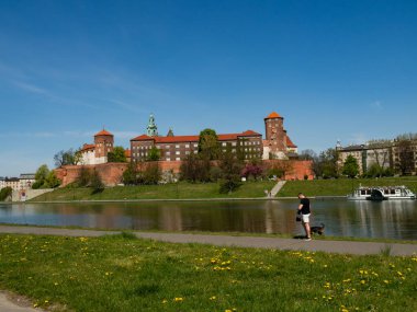 Krakow / Polonya - 23 / 04 / 2020. Polonya monarşisinin eski kraliyet konutu, Wawel Kalesi, Krakow, Polonya. Bahar zamanı, Vistula Nehri Bulvarı manzarası. İnsanlar covid-19 koronavirüs salgını sırasında rahatlıyor..