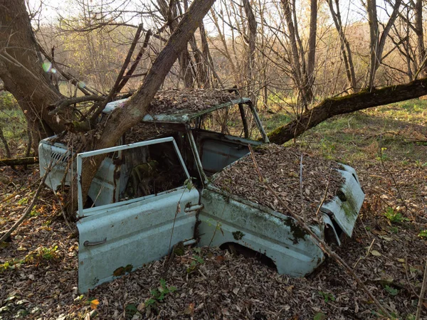 An abandoned village  and car scrap within the Chernobyl exclusion zone. Ukraine