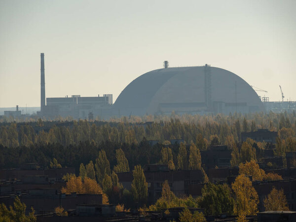 Вид с крыши города-призрака Припяти, постапокалиптического города и нового саркофага Чернобыльской АЭС осенний сезон в Чернобыльской зоне отчуждения, Украина
