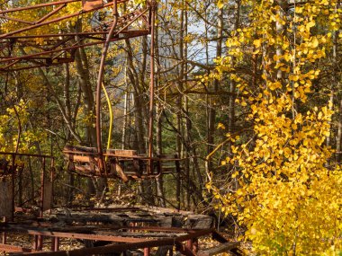 Pripyat 'ın hayalet kasabasındaki terk edilmiş eğlence parkı. Pripyat, Çernobil sınırlama bölgesindeki aşırı gelişmiş ağaçlar ve yıkılan binalar. Ukrayna