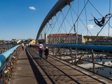 Krakow / Polonya - 27 / 04 / 2020. Vistula nehri üzerindeki Bernatek köprüsünde yürüyen insanlar.