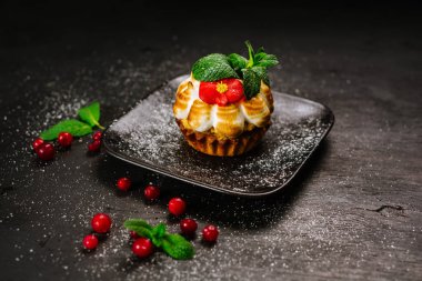 Siyah arka planda kızılcık olan tatlı kek.