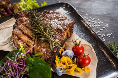 Siyah arka planda ızgara mermer biftek tabağı.