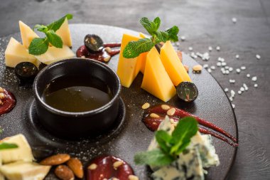 Ahşap zemin üzerinde çeşitli peynirler bulunan büyük tabak.