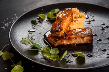 Siyah zemin üzerinde lahana olan taze kızarmış balık çubukları.