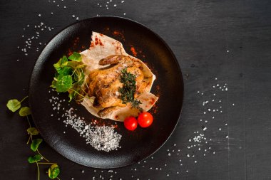 Siyah arka planda ızgara tavuk ve sebze.