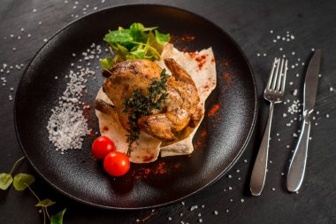 Siyah arka planda ızgara tavuk ve sebze.