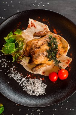 Siyah arka planda ızgara tavuk ve sebze.