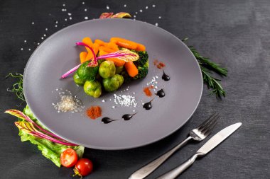 Siyah ahşap arka planda haşlanmış sebze.