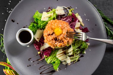 Siyah ahşap arka planda bir Tatar yemeği.