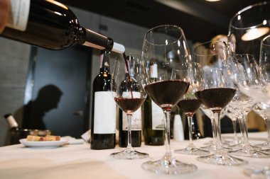 Birisi restorandaki bardağa şarap dolduruyor.