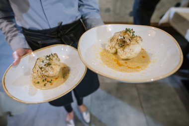 Restoranda bir garson müşterilere yemek getirir.