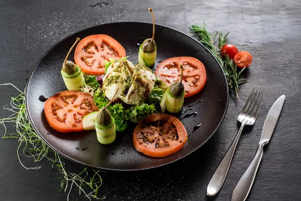 A dish from goat cheese and vegetables on black