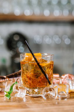 Ahşap masada buzlu bir viski.