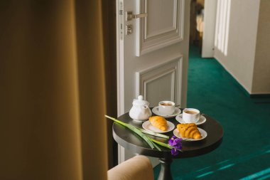 Tatlı kruvasanlar ve çay odanın içinde, pencerenin önünde.