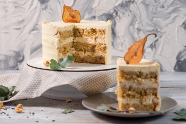 Beyaz ahşap arka planda karamelize armutlu vanilyalı kek.