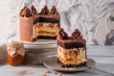 Beyaz ahşap arka planda yer fıstığı olan büyük bir çikolatalı pasta.