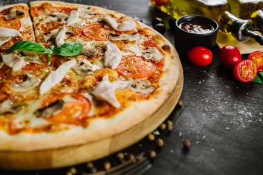 Siyah arka planda tavuk eti olan lezzetli bir pizza.