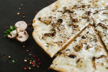 Siyah arka planda vejetaryen mantarlı pizza.