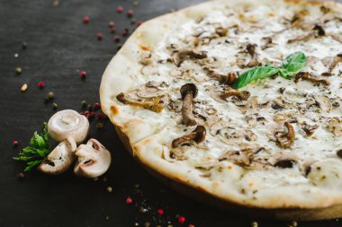 Siyah arka planda vejetaryen mantarlı pizza.