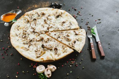 Siyah arka planda vejetaryen mantarlı pizza.