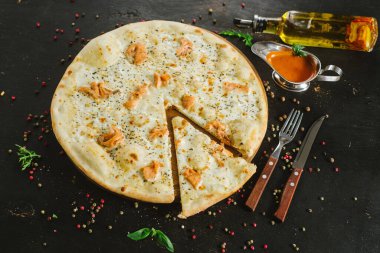 Siyah arka planda somon pizzası.