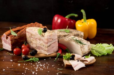 Ahşap zemin üzerinde baharat ve otlarla farklı tütsülenmiş et kompozisyonu