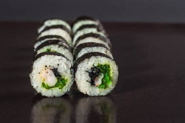 Siyah arka planda yılan balığı ile geleneksel Japon rulosu