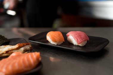 Siyah arka planda kırmızı balıklı büyük suşi.