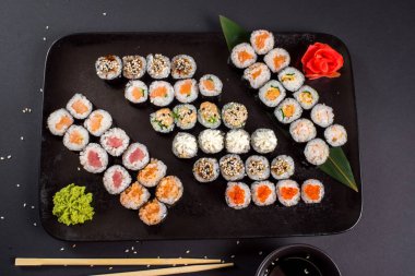 Japon suşi dürümleri siyah tabakta servis edilir.