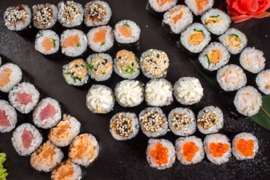 Japon suşi dürümleri siyah tabakta servis edilir.