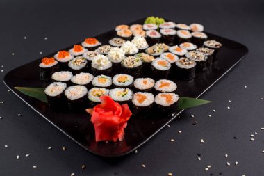 Japon suşi dürümleri siyah tabakta servis edilir.