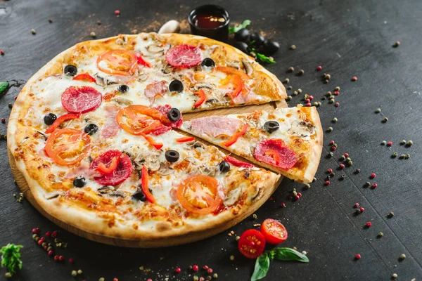 Delicious classic meat pizza on black background