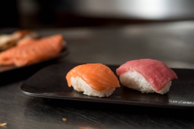 Siyah arka planda kırmızı balıklı büyük suşi.