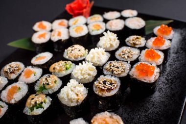 Japon suşi dürümleri siyah tabakta servis edilir.