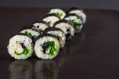 Siyah arka planda yılan balığı ile geleneksel Japon rulosu