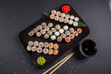 Japon suşi dürümleri siyah tabakta servis edilir.