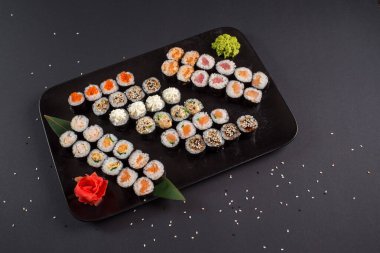 Japon suşi dürümleri siyah tabakta servis edilir.