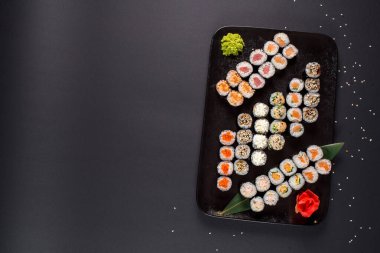 Japon suşi dürümleri siyah tabakta servis edilir.