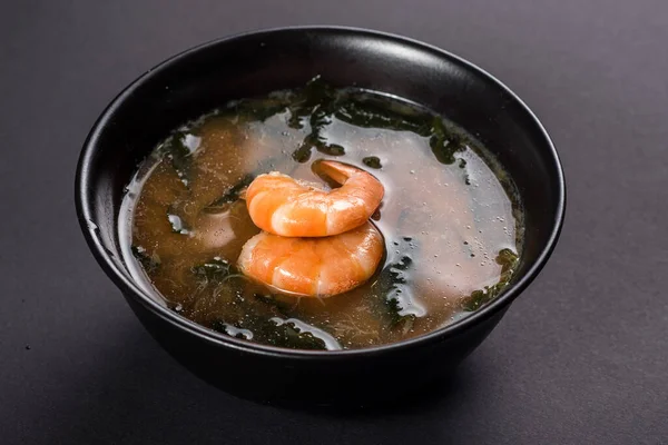 Siyah arka planda karidesli sıcak miso çorbası. Japon yemeği.