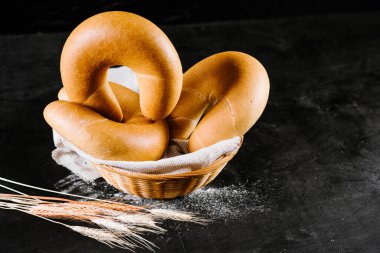 Siyah ahşap arka planda sepetin içinde taze çörekler