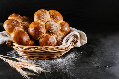 Siyah ahşap arka planda sepetin içinde taze çörekler